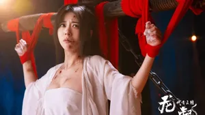 游戏《代号三国：龙起》宣传图，演员钱思怡饰演的角色邹素被绑在木桩上，身着古风服饰，面部表情略带伤感，身上可见浅色伤痕，背景为昏暗室内场景。