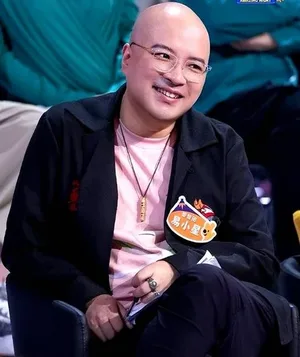 导演易小星在公开场合发言的现场照片,他身穿黑色上衣,站在话筒前,背景为蓝色幕布与活动主题字样。