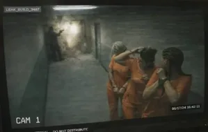 一张疑似《GTA6》的游戏截图,画面中一名深色短发女性角色身着橙色囚服,在昏暗室内环境中小跑前行,背景可见铁门与走廊结构