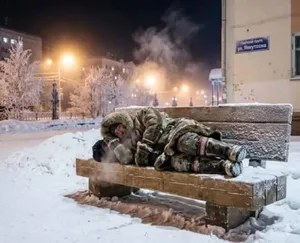 AI生成的示意图:一名男子身穿厚外套、戴毛线帽,闭眼仰靠在覆有薄雪的户外长椅上,面色苍白,周围环境呈现冬夜雪景,色调冷峻