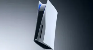 一张对比图，左侧为一台黑色Xbox Ally X掌机，右侧为一台白色PS5 Pro主机、一个黑色Dualsense Edge手柄和一台银色M2 iPad Air，三者并排摆放于浅色桌面上。