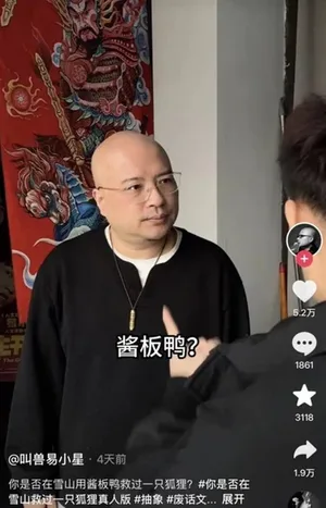 导演易小星在公开场合发言的现场照片,他身穿黑色上衣,站在话筒前,背景为蓝色幕布与活动主题字样,神情专注。