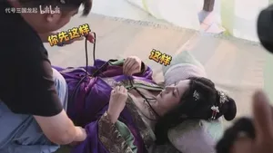 《代号三国:龙起》演员王星辰身着古风服饰,在摄影棚内拍摄甄宓角色的幕后工作照,背景可见灯光设备与工作人员。