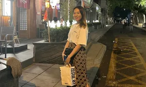 姜一郎对镜自拍，身穿黑色与红色背心，腹部明显隆起，双手轻扶孕肚，背景为简洁室内环境。