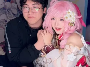 Coser‘一颗小兔娘’身着浅色系二次元风格服装，佩戴兔耳发饰，面带微笑面对镜头，背景为简洁室内环境，画面呈现其日常出镜形象。