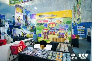 新物集BGM游戏展上海站现场照片:多人围站在一个布置有品牌标识的展台前,部分人手持手机拍摄,背景可见其他参展观众和展陈设施。