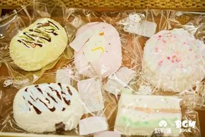 新物集BGM游戏展上海站现场照片:多人围站在一个布置有灯光与品牌标识的展台前,部分人手持手机拍摄,背景可见其他参展观众与展陈设施。