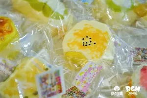 新物集BGM游戏展上海站现场,多人围在独立游戏试玩区展台前,有人专注操作屏幕上的游戏,有人站在后方观看,展台标有品牌标识和游戏画面。